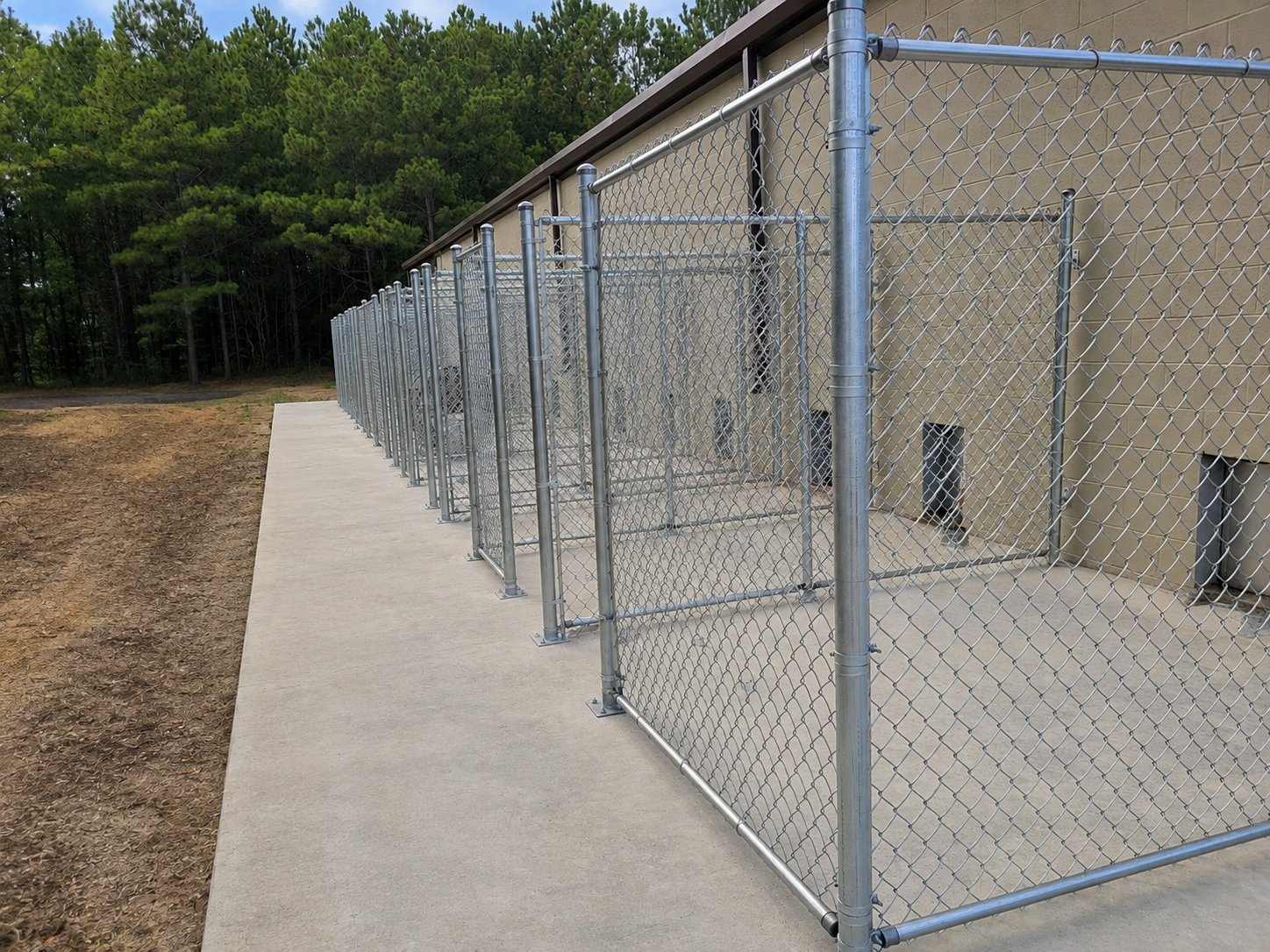 Commercial galvanized chain-link dog kennel enclosures installed by Hooks Fence Company in Northeast Alabama